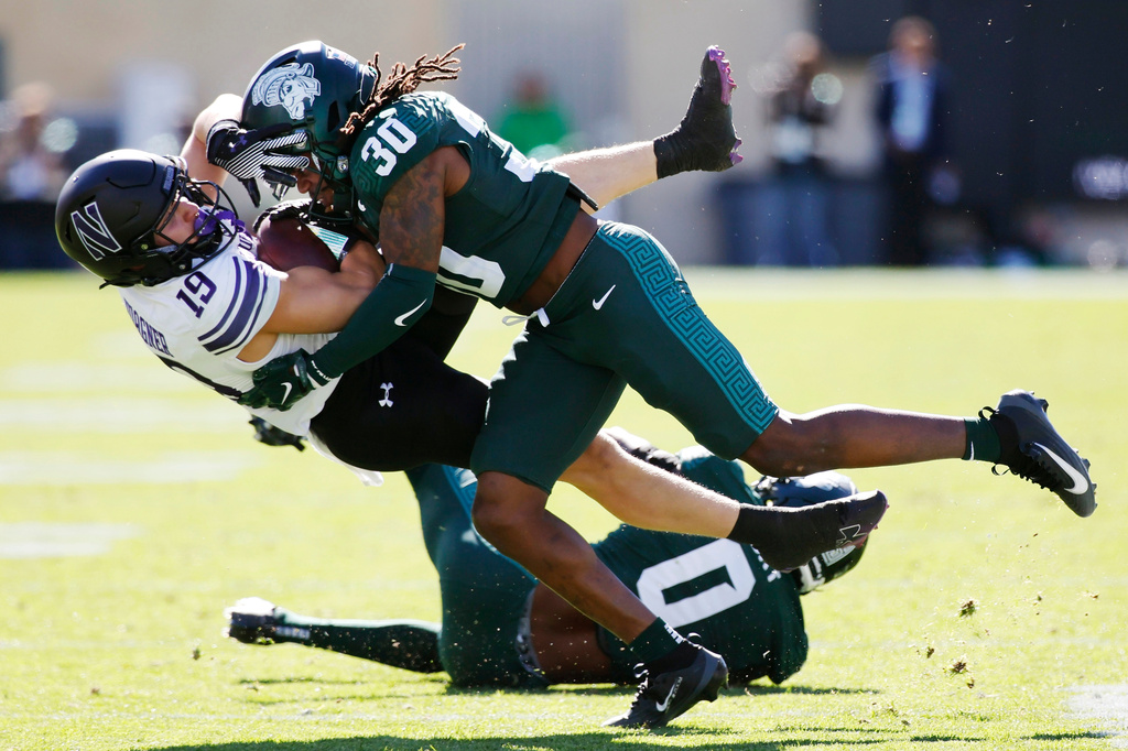 Northwestern wide receiver Drew Wagner (19) is tackled by Michigan State defensive back Aveon Grose (30) during the first half of an NCAA football game Saturday, Oct. 17, 2026, in East Lansing, Mich. (AP Photo/Duane Burleson)