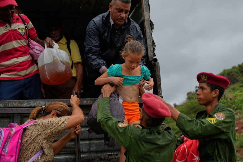 People evacuate before the arrival of Hurricane Melissa in Canizo, a community in Santiago de Cuba, Tuesday, Oct. 28, 2025. (AP Photo/Ramón Espinosa)