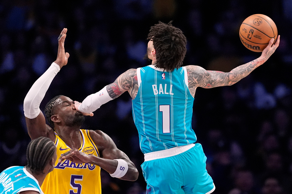 Charlotte Hornets guard LaMelo Ball, right, hits Los Angeles Lakers center Deandre Ayton in the face as he shoots during the first half of an NBA basketball game Thursday, Jan. 15, 2026, in Los Angeles. (AP Photo/Mark J. Terrill)