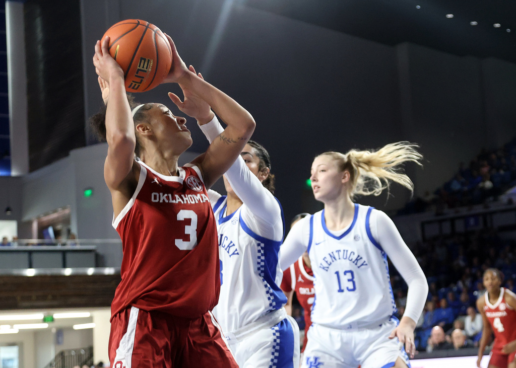 Oklahoma's Zya Vann (3) shoots near the defense of Kentucky's Jordan Obi, center, and Clara Strack (13) during the first quarter of an NCAA college basketball game in Lexington, Ky., Sunday, Jan. 11, 2026. (AP Photo/James Crisp)
