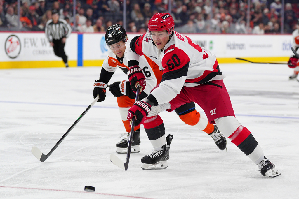 Carolina Hurricanes' Eric Robinson, right, battles for the puck against Philadelphia Flyers' Emil Andrae, left, during the first period of an NHL hockey game, Saturday, Dec. 13, 2025, in Philadelphia. (AP Photo/Derik Hamilton)