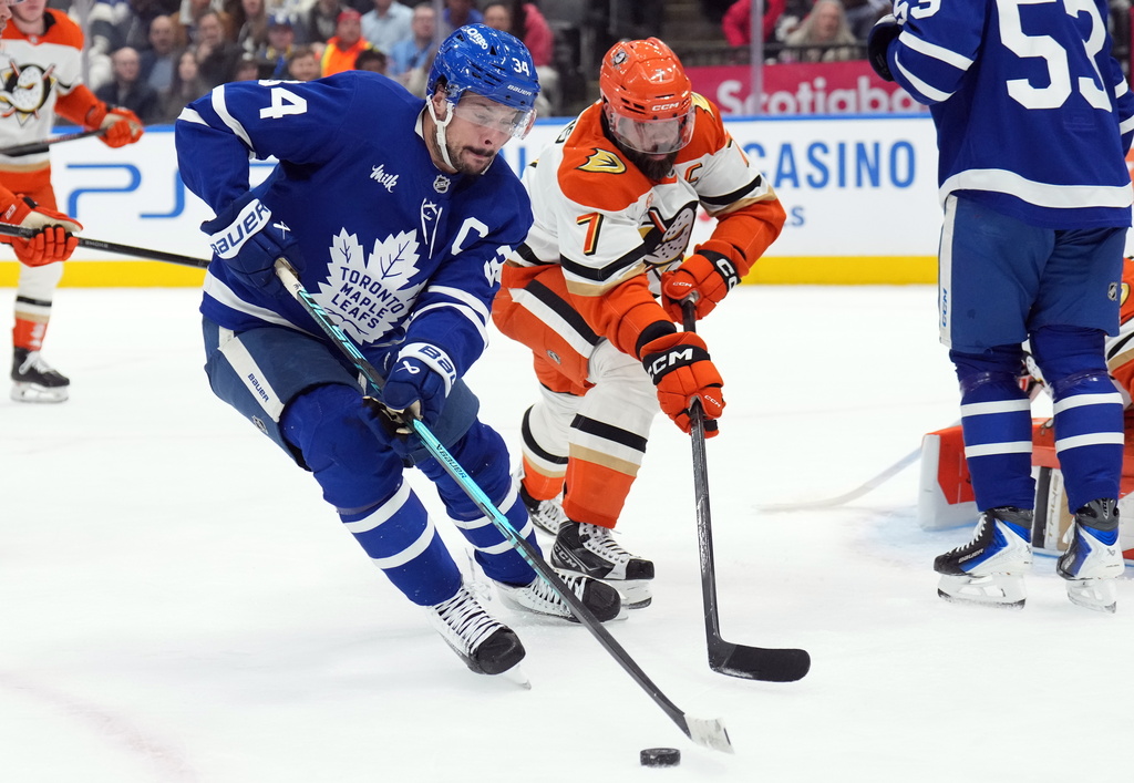 Toronto Maple Leafs Auston Matthews (34) and Anaheim Ducks Radko Gudas (7) battle for the puck during second period NHL hockey action in Toronto on Thursday, March 12, 2026. (Nathan Denette/The Canadian Press via AP)