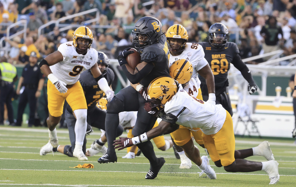 Baylor running back Bryson Washington (7) is tackled by Arizona State safety Boggie Wilson, right, and Arizona State linebacker Keyshawn Elliott (44) in the first half of an NCAA college football game, Saturday, Sept. 20, 2025, in Waco, Texas. (AP Photo/Jerry Larson)