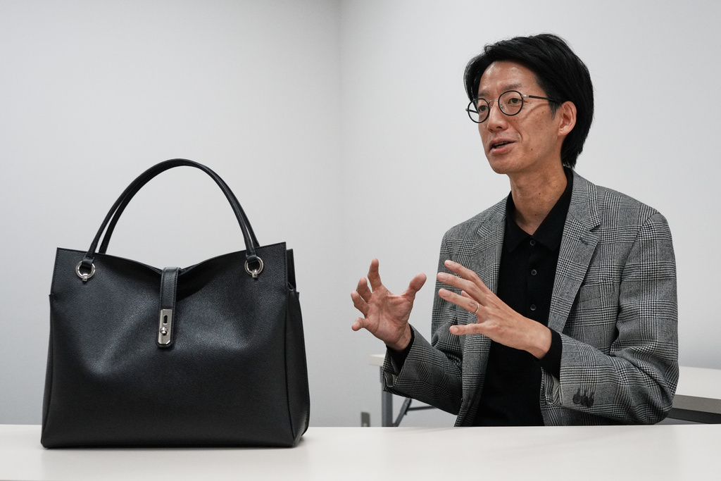 Takanori Kobayashi, a public relations officer at Hamano Leather Crafts Co., Ltd., a long-established Japanese maker of leather goods, shows the same model of handbag used by Prime Minister Sanae Takaichi, Tuesday, Dec. 2, 2025, in Tokyo. (AP Photo/Eugene Hoshiko)