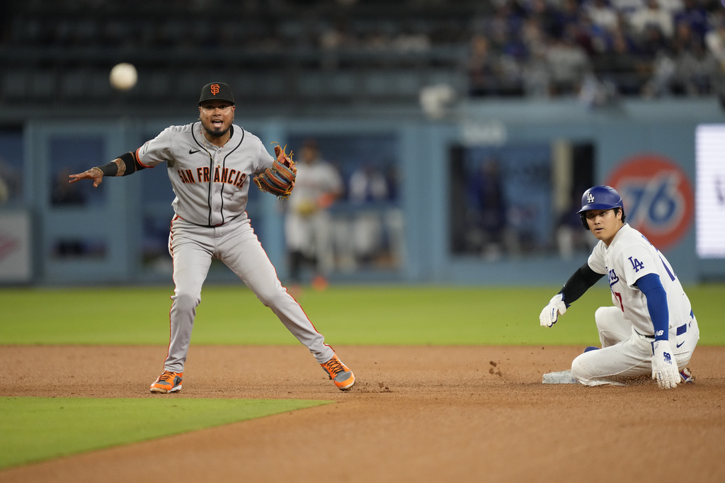 Los Angeles Dodgers' Shohei Ohtani, right, is forced out at second as San Francisco Giants second baseman Luis Arraez throws out Mookie Betts at first during the fifth inning of a baseball game Tuesday, May 12, 2026, in Los Angeles. (AP Photo/Mark J. Terrill)