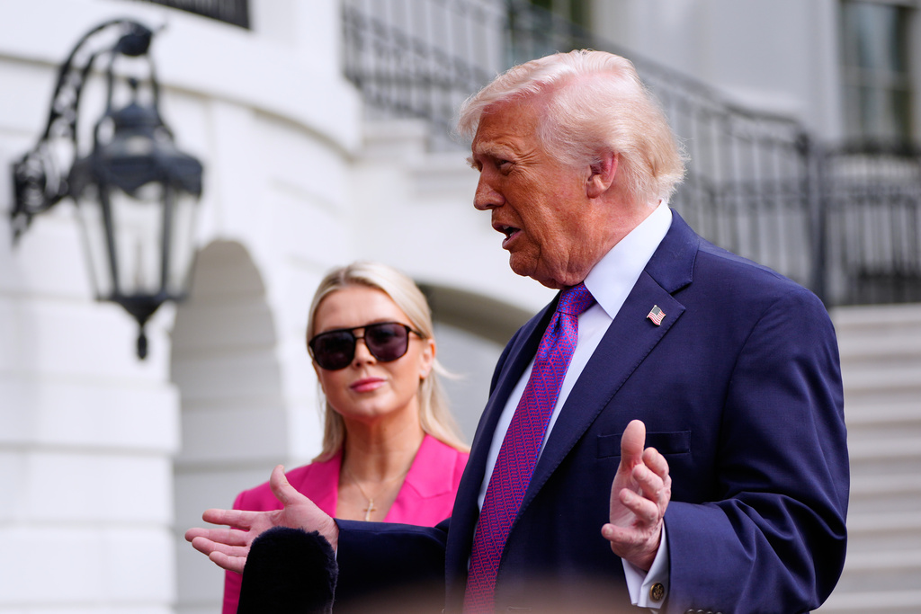 President Donald Trump speaks with reporters as he walks to depart on Marine One from the South Lawn of the White House, Wednesday, March 11, 2026, in Washington, as White House press secretary Karoline Leavitt, looks on. (AP Photo/Alex Brandon)