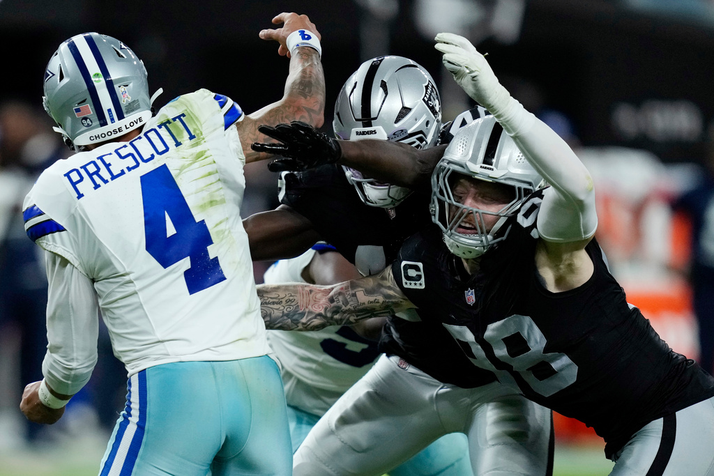 Las Vegas Raiders defensive end Maxx Crosby and Raiders linebacker Jamin Davis puts pressure on Dallas Cowboys quarterback Dak Prescott (4) during the first half of an NFL football game Monday, Nov. 17, 2025, in Las Vegas. (AP Photo/John Locher)