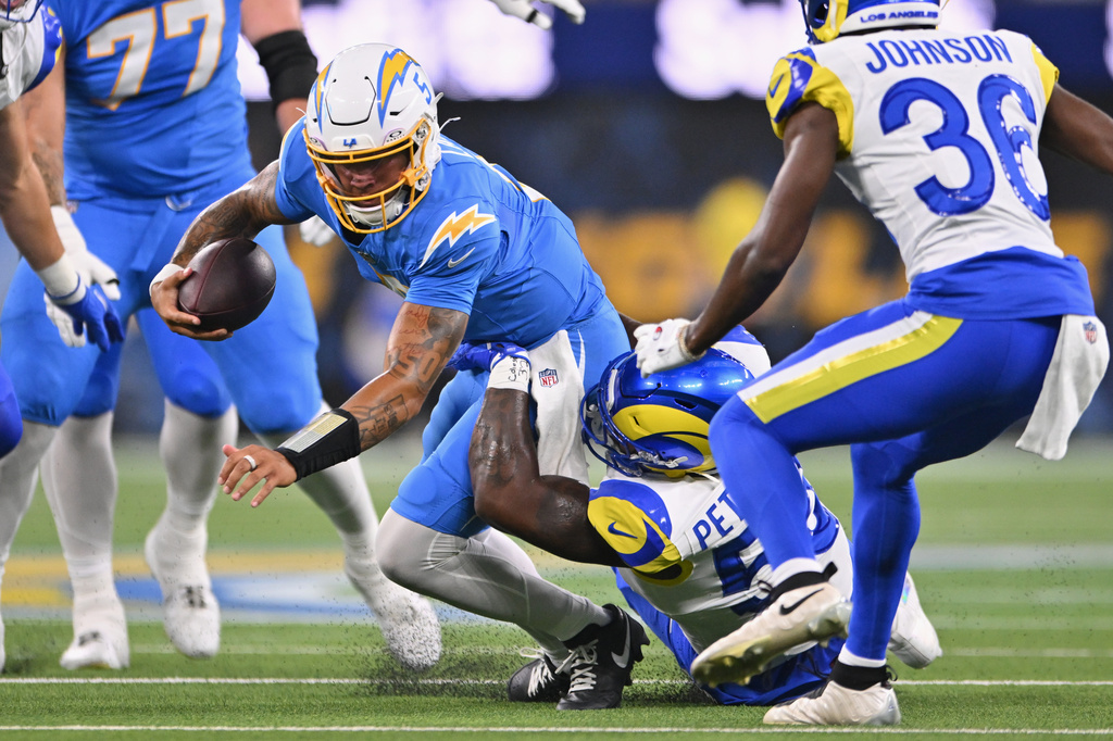 Los Angeles Chargers quarterback Trey Lance, above, is brought down by Los Angeles Rams linebacker Darryl Peterson III for a sack during the first half of an NFL preseason football game Thursday, Aug. 27, 2026, in Inglewood, Calif. (AP Photo/Katie Chin)