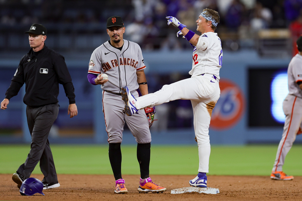 Los Angeles Dodgers' Alex Call, right, celebrates near San Francisco Giants shortstop Willy Adames after hitting an RBI single during the sixth inning of a baseball game Thursday, May 14, 2026, in Los Angeles. (AP Photo/Ryan Sun)