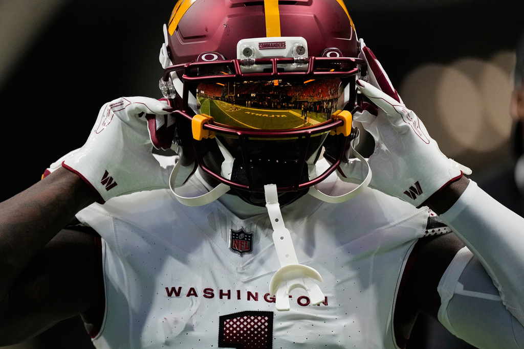The field is reflected in Washington Commanders wide receiver Deebo Samuel Sr.'s visor as he warms up before an NFL football game against the Atlanta Falcons, Sunday, Sept. 28, 2025, in Atlanta. (AP Photo/Brynn Anderson)