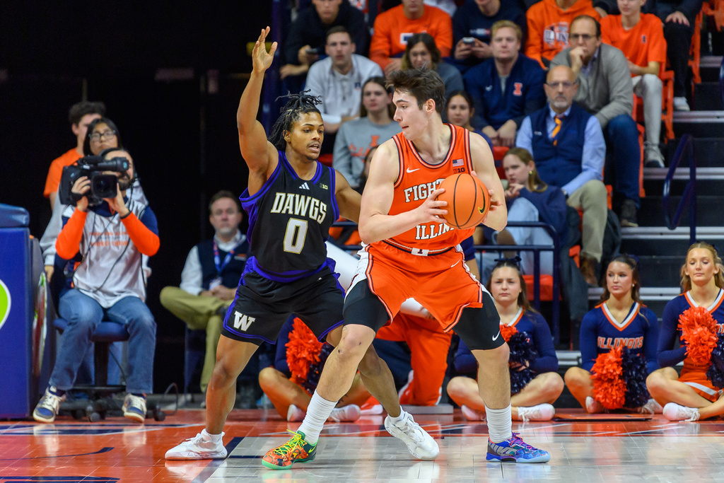 Illinois forward David Mirkovic, center right, looks for an opening as Washington's Quimari Peterson (0) defends during the second half of an NCAA college basketball game Thursday, Jan. 29, 2026, in Champaign, Ill. (AP Photo/Craig Pessman)