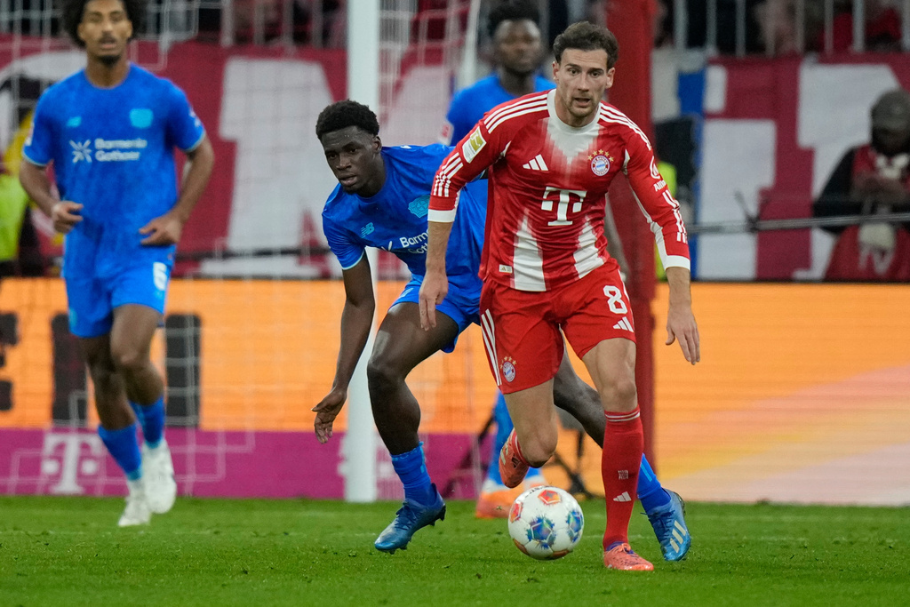 Bayern's Leon Goretzka is challenged by Leverkusen's Ernest Poku, rear, during the German Bundesliga soccer match between Bayern Munich and Bayern Leverkusen in Munich, Germany, Saturday, Nov. 1, 2025. (AP Photo/Matthias Schrader)