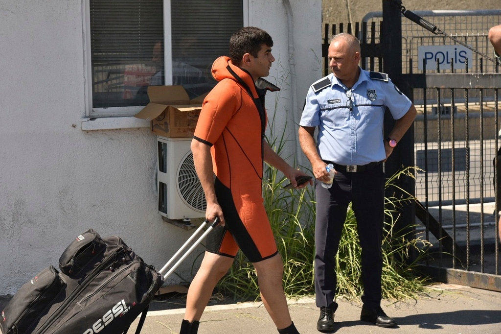 A survivor of a catamaran-style ferry which was capsized off the coast of northern Cyprus, arrives at the port of Kyrenia in the Turkish occupied northern part of Cyprus, Sunday, Aug. 30, 2026. (AP Photo) CORRECTION: a man instead of a survivor