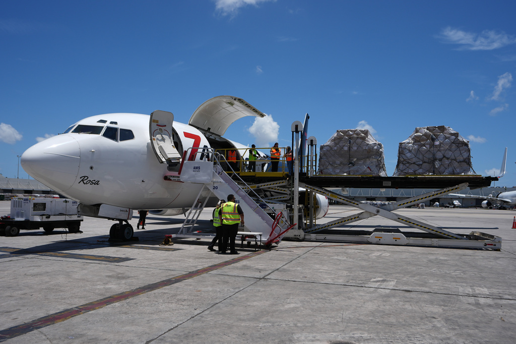 People load pallets containing food and hygiene kits for a humanitarian assistance flight to Cuba organized by the Trump administration as the U.S. continues to put pressure on the island's government, Tuesday, July 21, 2026, in Miami. (AP Photo/Lynne Sladky)