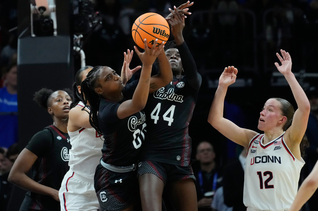 South Carolina guard Ta'Niya Latson (00) and South Carolina guard Agot Makeer (44) go for a rebound against UConn during the first half of a woman's NCAA college basketball tournament semifinal game at the Final Four, Friday, April 3, 2026, in Phoenix. (AP Photo/Ross D. Franklin)