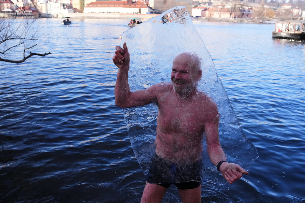 Polar swimmer holds up a block of ice during the traditional Three Kings swim in the Vltava River in Prague, Czech Republic, Tuesday, Jan. 6, 2026. (AP Photo/Petr David Josek)