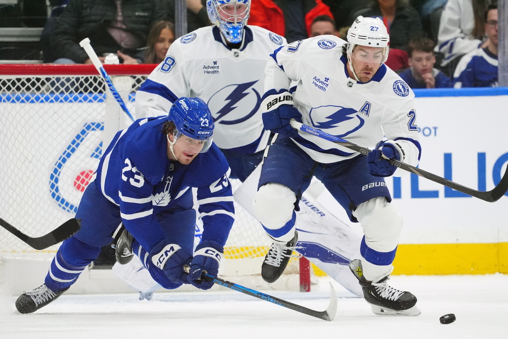 Toronto Maple Leafs Matthew Knies (23) and Tampa Bay Lightning Ryan McDonagh (27) battle for the puck during first period NHL action in Toronto, on Saturday, March 7, 2026. (Frank Gunn/The Canadian Press via AP)