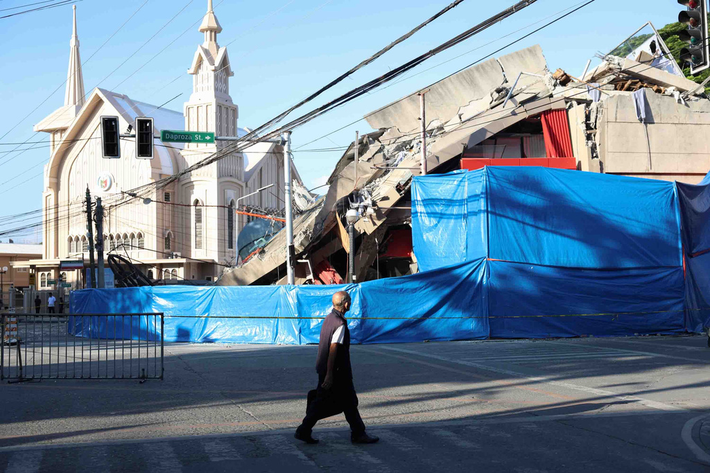 A man walks past a damaged building following an earthquake in General Santos, Philippines Tuesday, June 9, 2026. (AP Photo/Basilio Sepe)