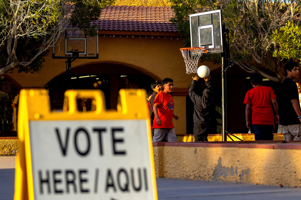 FILE - Kids play outside a polling precinct, Tuesday, March 19, 2024, in Guadalupe, Ariz. (AP Photo/Ty ONeil)