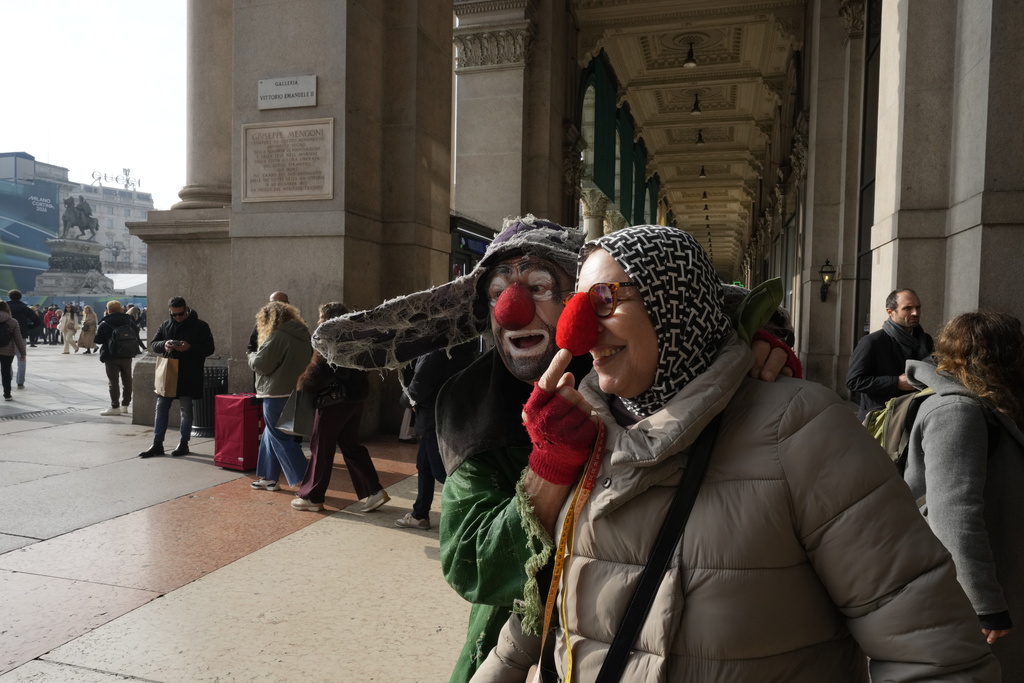 A performer from the Snowshow at the Piccolo Teatro Grassi reacts with a passer by, ahead of the 2026 Winter Olympics, in Milan, Italy, Friday, Jan. 30, 2026. (AP Photo/Luca Bruno)