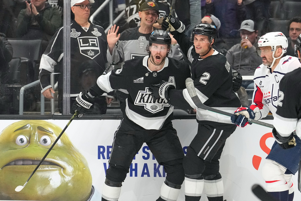 Los Angeles Kings right wing Adrian Kempe, left, celebrates his goal with defenseman Brian Dumoulin, center, as Washington Capitals left wing Alex Ovechkin skates by during the second period of an NHL hockey game Tuesday, Dec. 2, 2025, in Los Angeles. (AP Photo/Mark J. Terrill)