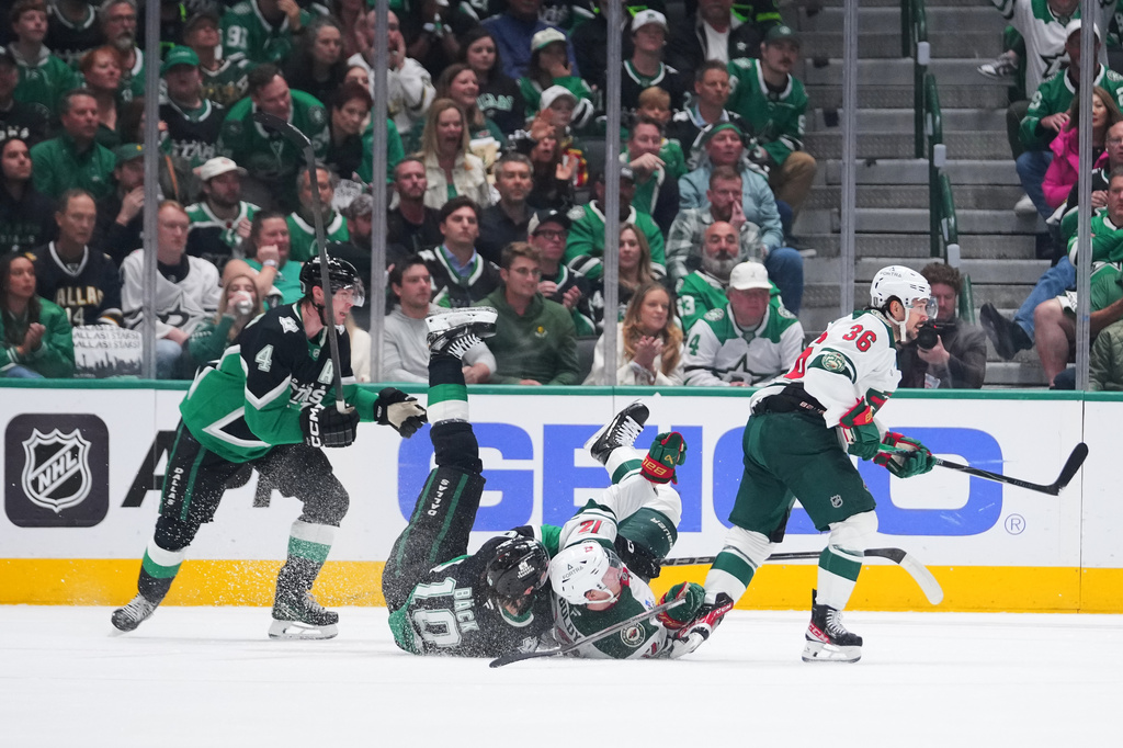 Dallas Stars center Oskar Bäck (10) collides with Minnesota Wild left wing Matt Boldy (12) as Stars' defenseman Miro Heiskanen (4) and Wild right wing Mats Zuccarello (36) eye the puck during the first period in Game 5 of a first-round NHL Stanley Cup playoffs hockey series, Tuesday, April 28, 2026, in Dallas. (AP Photo/Julio Cortez)