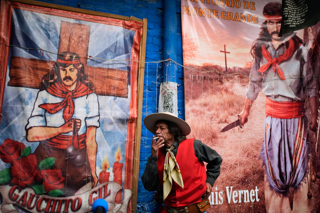 FILE - Enrique Alberto Viana smokes at one of sanctuaries of "Gauchito" Gil on the folk saint's annual feast day when believers ask for miracles or thank him, in Buenos Aires, Argentina, Jan. 8, 2026. (AP Photo/Natacha Pisarenko, File)