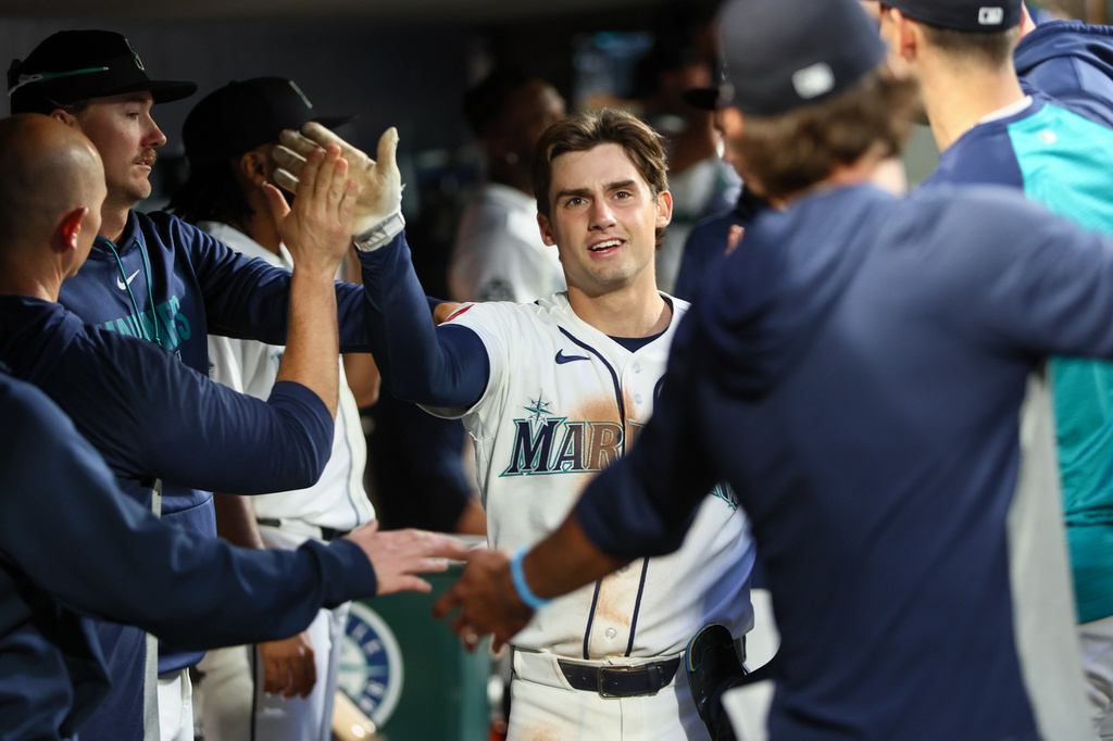 Seattle Mariners' Cole Young (2) celebrates with teammates in the dugout after scoring on a single hit by Victor Robles in the seventh inning of a baseball game against the Los Angeles Angels, Tuesday, June 30, 2026, in Seattle. (AP Photo/Kevin Ng)