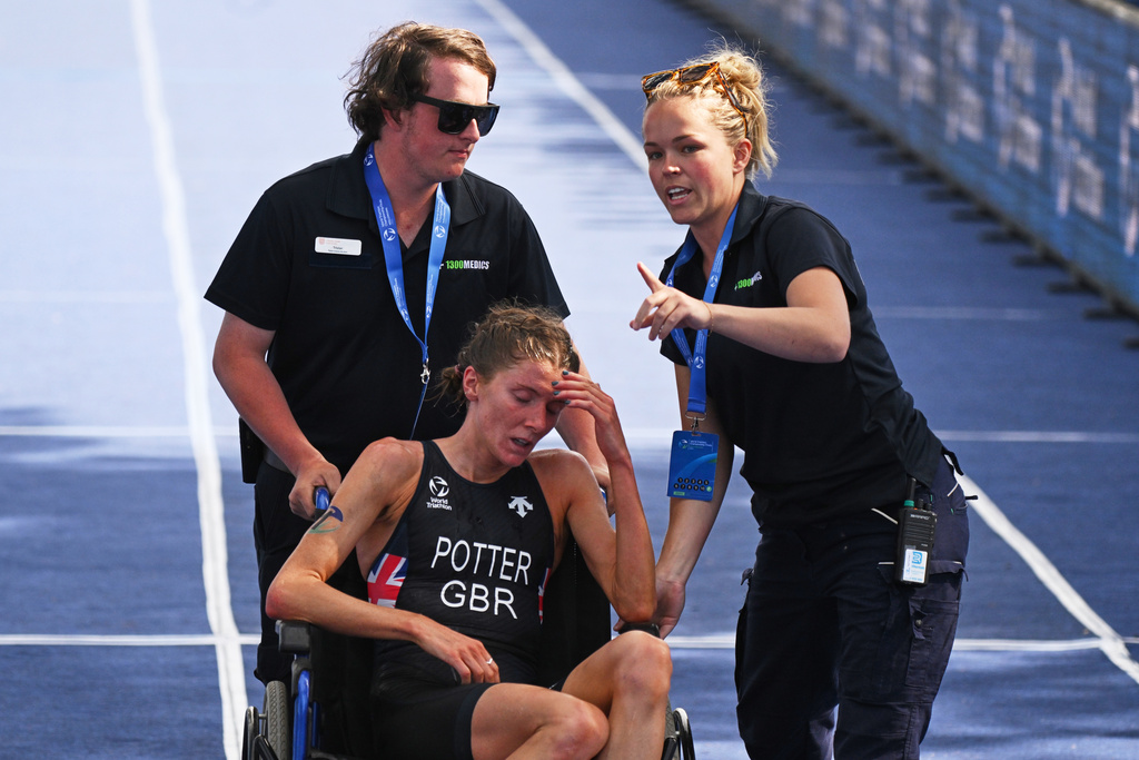 Beth Potter of Britain is assisted from the finish line at the World Triathlon Championships in Wollongong, Australia, Sunday, Oct. 19, 2025. (Dean Lewins/AAPImage via AP)