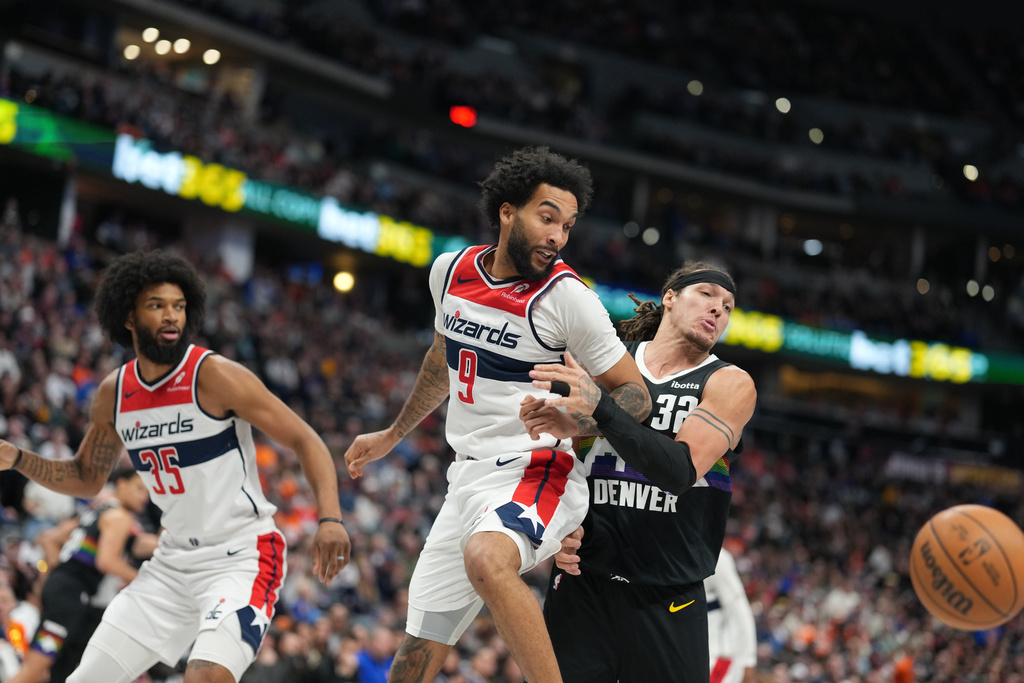 Denver Nuggets forward Aaron Gordon, right, pursues the ball with Washington Wizards guard Justin Champagnie, center, and forward Marvin Bagley III, left, in the second half of an NBA basketball game Saturday, Jan. 17, 2026, in Denver. (AP Photo/David Zalubowski)