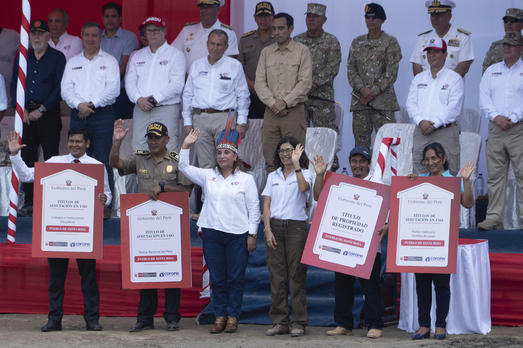 Peru's President Dina Boluarte poses with residents after presenting land titles during a visit to Santa Rosa, an island on the Amazon River at the triple border with Colombia and Brazil, amid a territorial dispute with Colombia, Friday, Aug. 15, 2025. (AP Photo/Daniel Padilla)