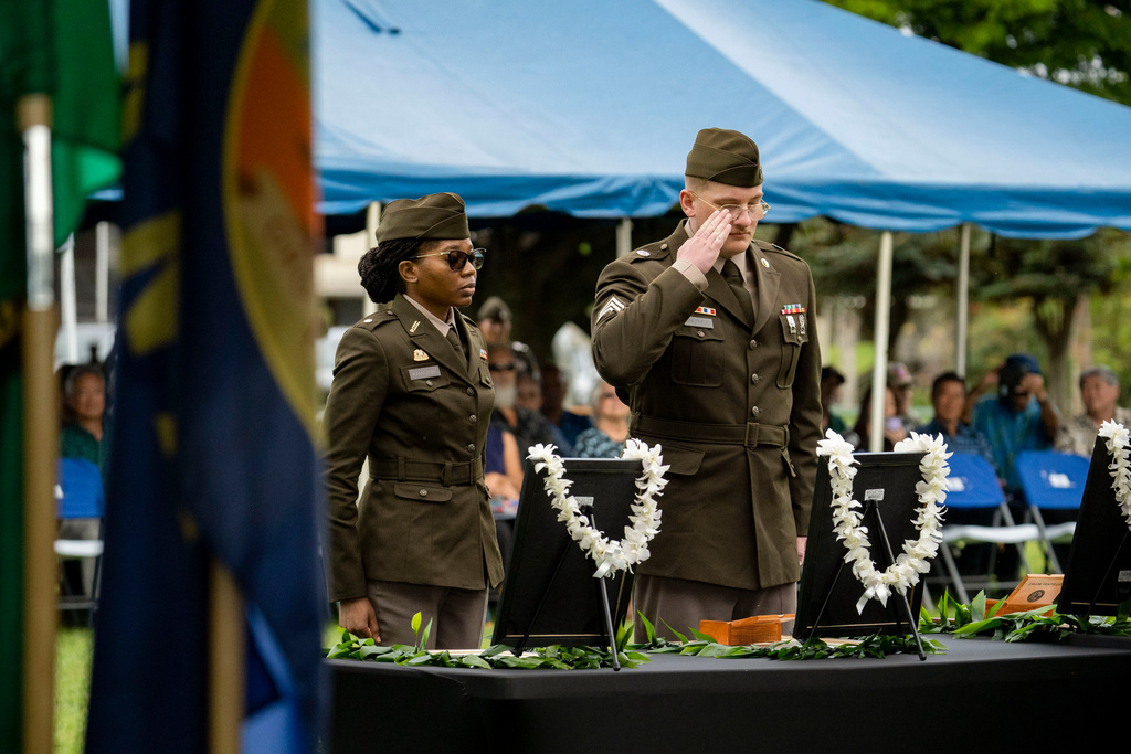 U.S. Army soldiers salute framed photos of former University of Hawaii ROTC cadets during a posthumous commissioning ceremony at Ke'ehi Lagoon Memorial Park, Monday, Jan. 26, 2026, in Honolulu. (AP Photo/Mengshin Lin)