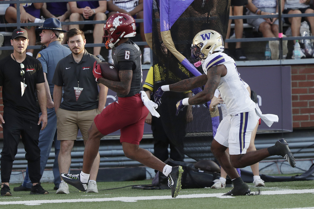 Washington State wide receiver Devin Ellison (6) secures a pass while pressured by Washington cornerback Leroy Bryant, right, during the first half of an NCAA college football game, Saturday, Sept. 20, 2025, in Pullman, Wash. (AP Photo/Young Kwak)