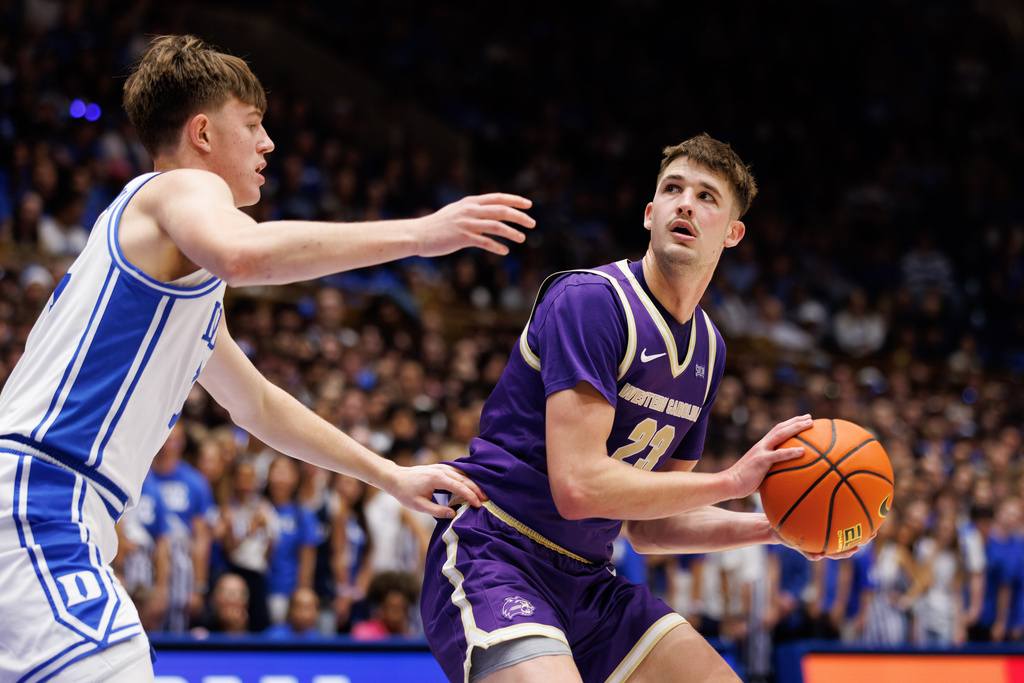 Western Carolina's Marcus Kell (23) looks for an outlet as Duke's Nikolas Khamenia, left, defends during the first half of an NCAA college basketball game in Durham, N.C., Saturday, Nov. 8, 2025. (AP Photo/Ben McKeown)