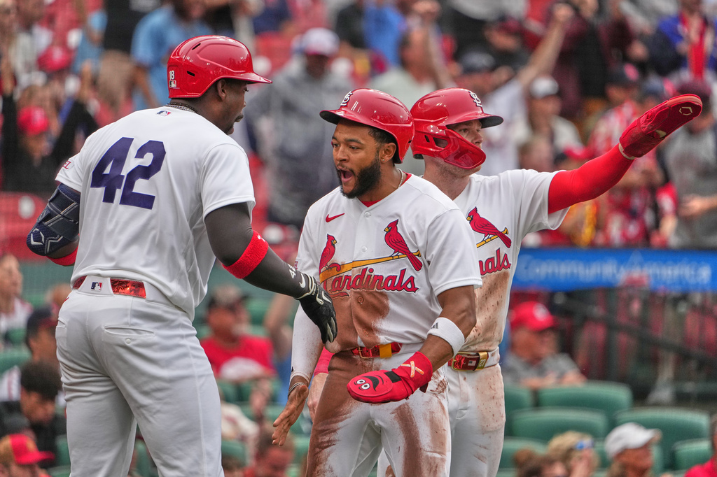 St. Louis Cardinals' Victor Scott II, center, and Nathan Church, right, are congratulated by teammate Jordan Walker, left, after scoring during the sixth inning of a baseball game against the Cleveland Guardians Wednesday, April 15, 2026, in St. Louis. (AP Photo/Jeff Roberson)