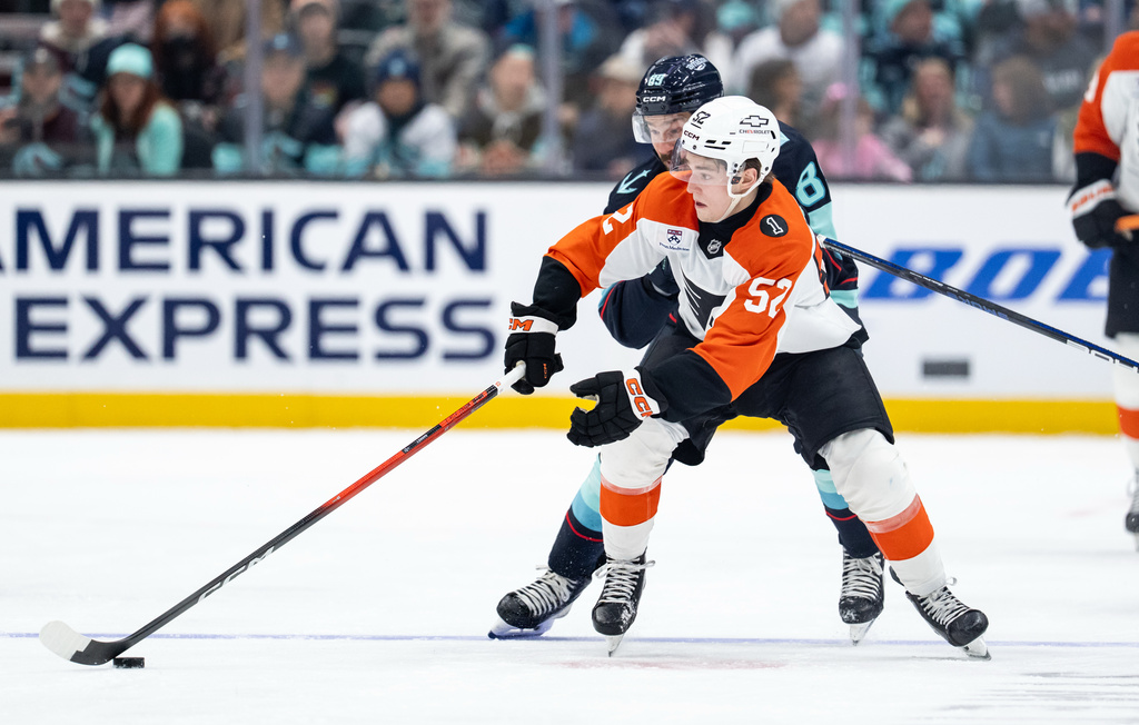 Philadelphia Flyers forward Denver Barkey (52) and Seattle Kraken forward Frederick Gaudreau battle for the puck during the second period of an NHL hockey game, Sunday, Dec. 28, 2025, in Seattle. (AP Photo/Stephen Brashear)