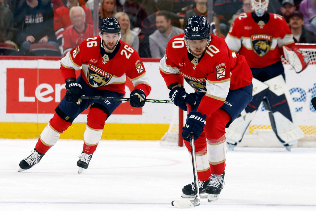 Florida Panthers' A.J. Greer (10) settles the puck with Florida Panthers' Uvis Balinskis (26) nearby during the first period of an NHL hockey game against the Carolina Hurricanes in Raleigh, N.C., Tuesday, Dec. 23, 2025. (AP Photo/Karl DeBlaker)