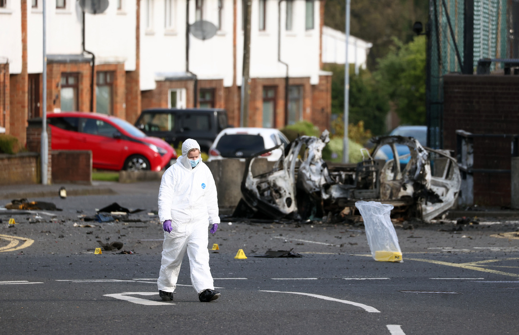 Forensic investigators inspect the site of a car bomb that exploded outside Dunmurry police station in South Belfast, Sunday, April 26, 2026. (AP Photo/Peter Morrison)