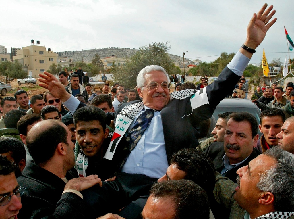 FILE - Interim Palestinian leader Mahmoud Abbas, is carried by the Al Aqsa Martyrs' Brigades leader in West Bank, Zakaria Zubeidi, center left, during a campaign visit to the Jenin refugee camp Dec. 30, 2004.(AP Photo/Enric Marti, File)