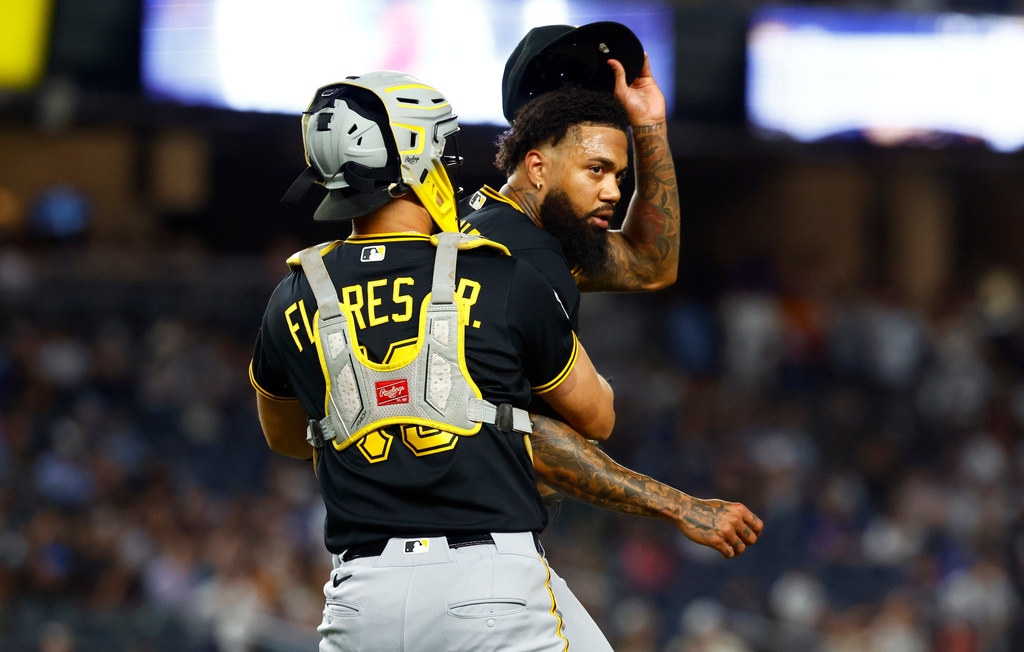 Pittsburgh Pirates catcher Rafael Flores Jr. keeps pitcher Dennis Santana from going after New York Yankees' José Caballero during the ninth inning of a baseball game, Monday, July 20, 2026 in New York. (AP Photo/Noah K. Murray)