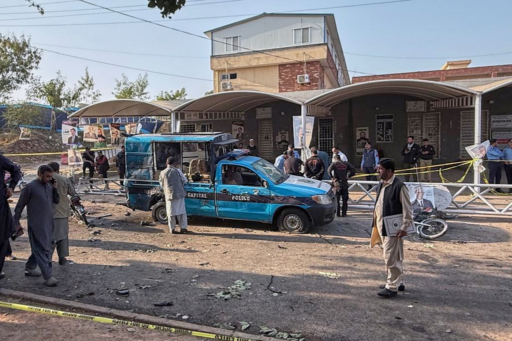 Security officials examine a damage vehicle at the site following a suicide bombing outside the gates of a district court, in Islamabad, Pakistan, Tuesday, Nov. 11, 2025. (AP Photo/Mohammad Yousuf)
