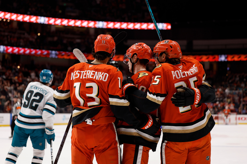 Anaheim Ducks right wing Troy Terry (19), center, is congratulated by teammates after scoring against the San Jose Sharks during the first period of an NHL hockey game Monday, Dec. 29, 2025, in Anaheim, Calif. (AP Photo/Caroline Brehman)