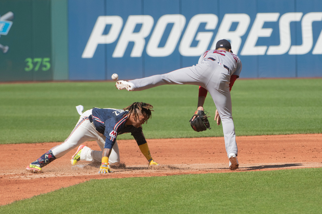 Cleveland Guardians' Jose Ramirez, left, is safe at second base as Boston Red Sox' Isiah Kiner-Falefa misses the throw during the first inning of a baseball game, Saturday, May 30, 2026, in Cleveland. (AP Photo/Phil Long)