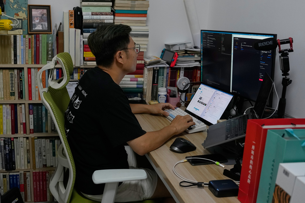Fei Zhaojun, a former software engineer works on his computer at his home in Beijing on July 13, 2026. (AP Photo/Andy Wong)