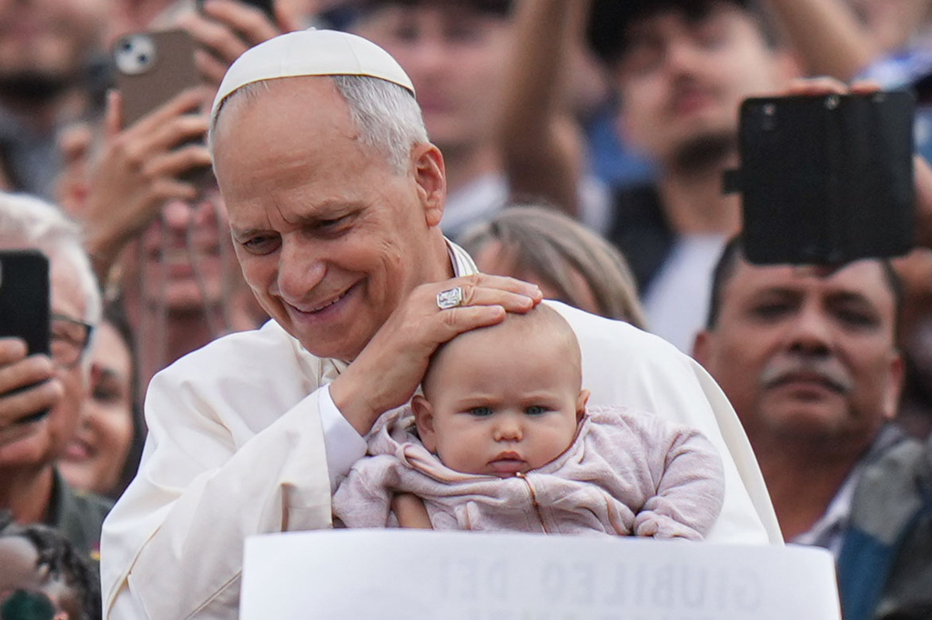 Pope Leo XIV blesses a child at the end of a Mass for the Jubilee of Migrants and Missionaries in St. Peter's Square at the Vatican, Sunday, Oct. 5, 2025. (AP Photo/Alessandra Tarantino)