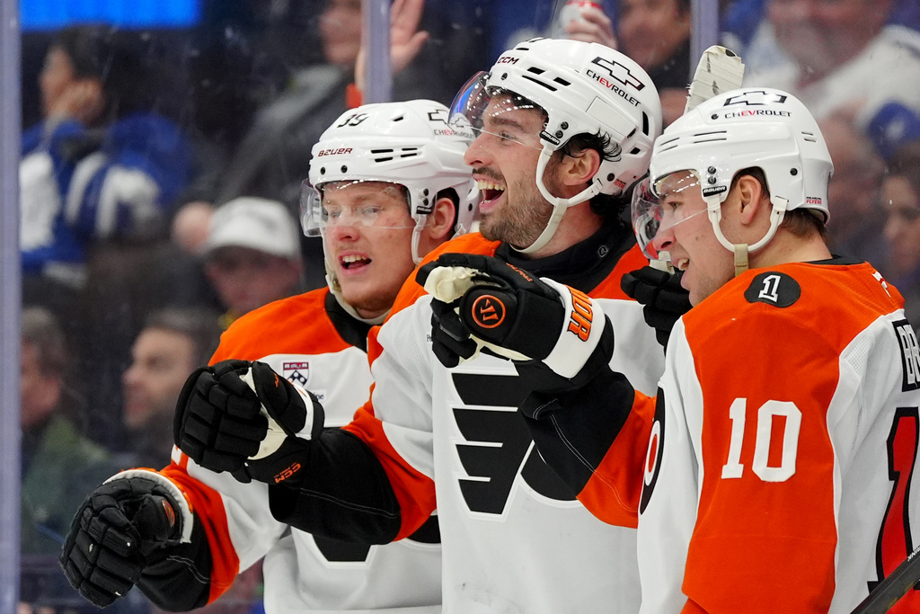 Philadelphia Flyers' Noah Cates, center, celebrates after his goal with teammates Matvei Michkov (39) and Bobby Brink (10) during third-period NHL hockey game action against the Toronto Maple Leafs in Toronto, Monday, March 2, 2026. (Frank Gunn/The Canadian Press via AP)