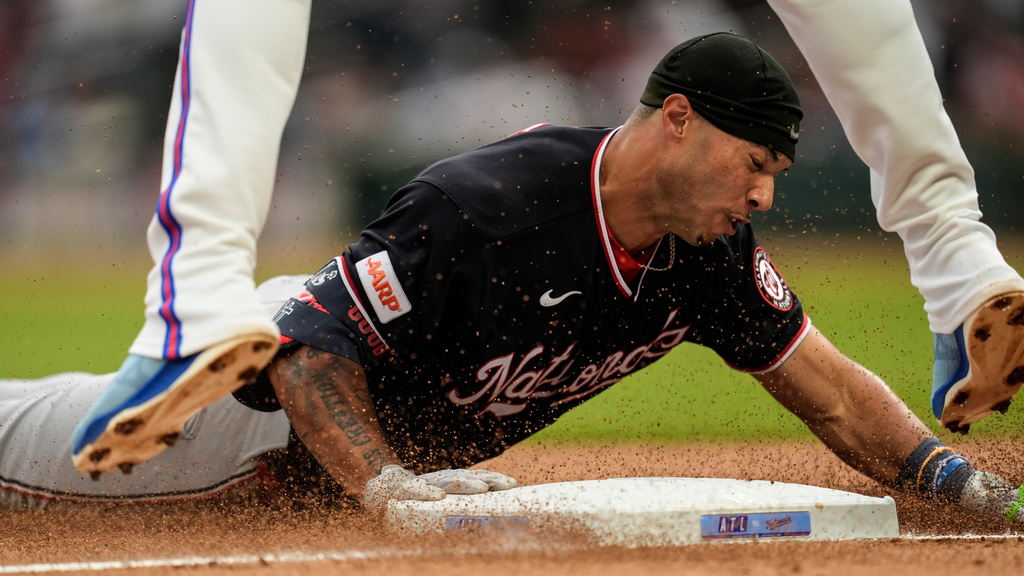 Washington Nationals' Daylen Lile slides into third base after hitting a triple in the second inning of a baseball game against the Atlanta Braves, Saturday, May 23, 2026, in Atlanta. (AP Photo/Mike Stewart)