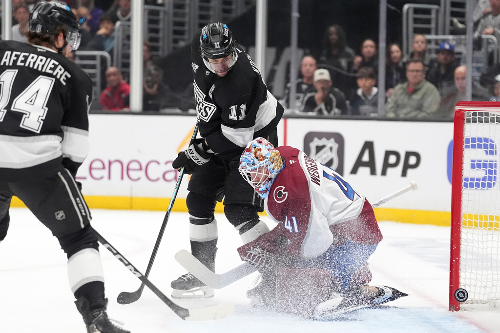 Los Angeles Kings' Anze Kopitar (11) watches a shot by Joel Edmundson get past Colorado Avalanche goaltender Scott Wedgewood for goal during the second period of Game 4 in the first round of an NHL hockey Stanley Cup playoff series Sunday, April 26, 2026, in Los Angeles. (AP Photo/Scott Strazzante)