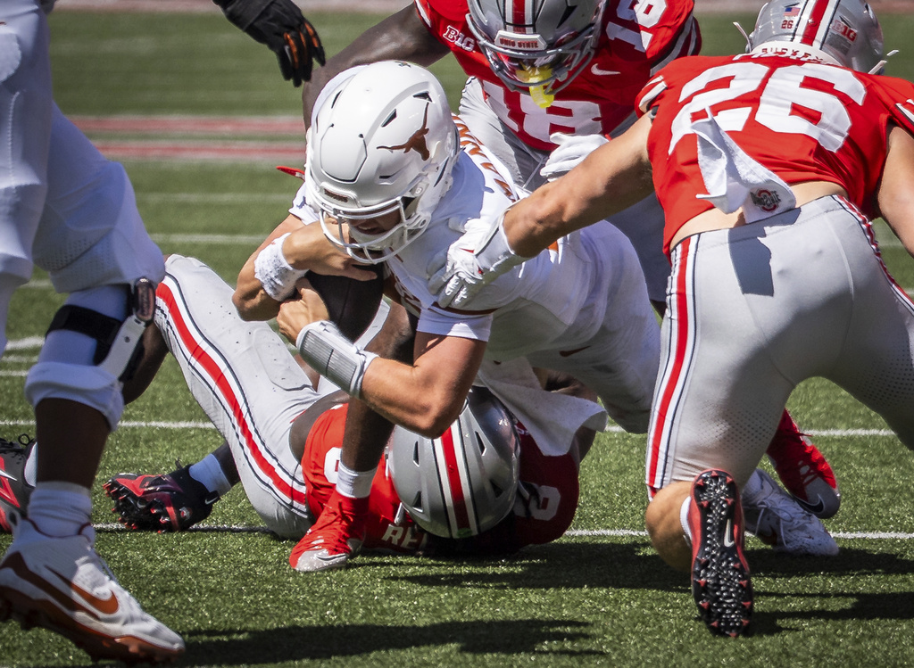Texas quarterback Arch Manning (16) goes down after a defensive effort from Ohio State linebackers Arvell Reese (8) and Payton Pierce (26) as well as safety Jaylen McClain (18) in the second half of an NCAA college football game, Saturday, Aug. 30, 2025., in Columbus, Ohio. (Sara Diggins/Austin American-Statesman via AP)