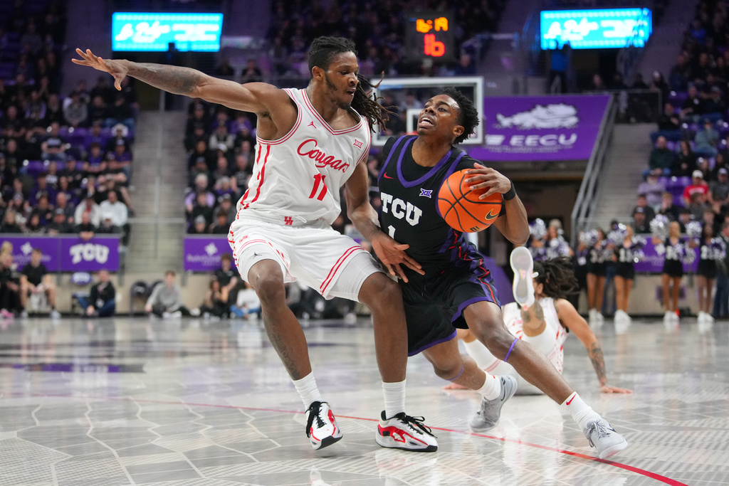 TCU guard Jayden Pierre, right, drives against Houston forward Joseph Tugler during the first half of an NCAA college basketball game Wednesday, Jan. 28, 2026, in Fort Worth, Texas. (AP Photo/Julio Cortez)